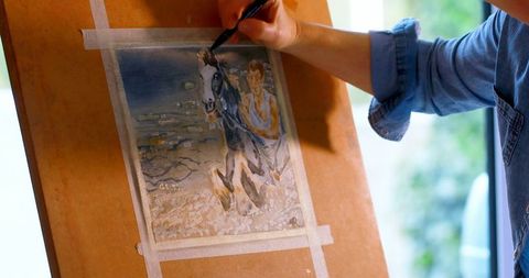 Female artist painting horse with sketch pen at home