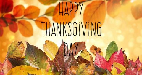 Warm golden thanksgiving greeting with autumn leaf pile and soft bokeh