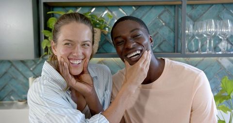 Diverse Couple Smiling in Modern Kitchen Setting