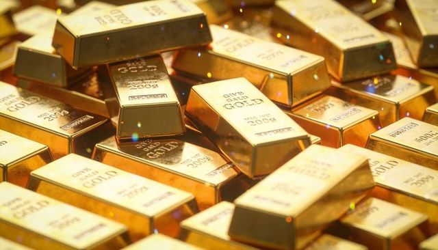 Stacked gold bars in vault shining polished bullion ingots showing stamped weight