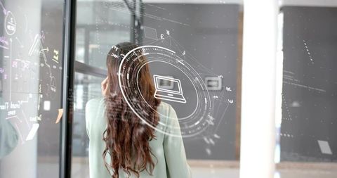 Rear view of woman analyzing digital interface with laptop icon
