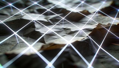 Crumpled paper terrain showing neon diamond grid projection with lens flares