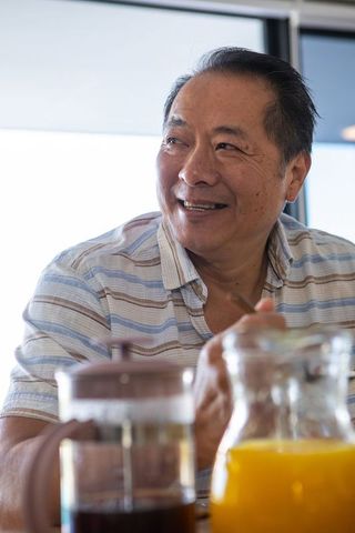 Mature Asian Man Enjoying Casual Breakfast Setting