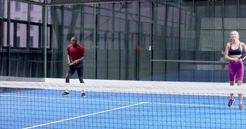 Diverse Padel Players Engaging Actively on Indoor Court