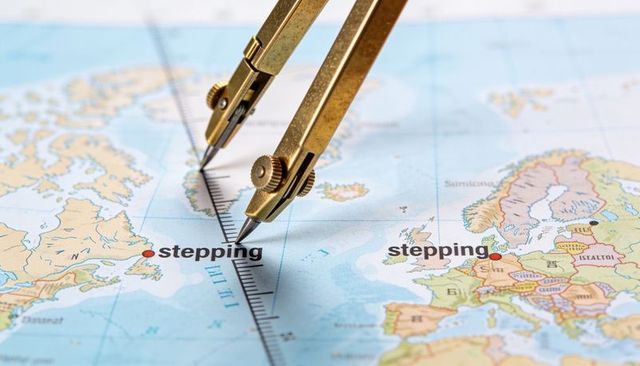 Brass dividers marking north atlantic meridian on vintage world map with red waypoints
