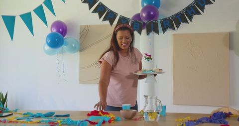Smiling Woman Arranging Colorful Birthday Decorations at Home