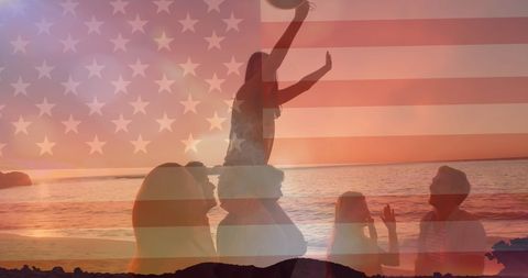 Group of Friends at Sunset Beach Celebrating Under American Flag