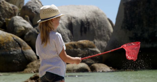 Young Girl Fishing with Net by Rocky Shore - Download Free Stock Images Pikwizard.com