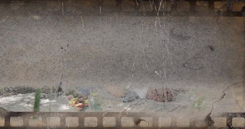 Vintage film-strip with distressed sprocket holes, scratched wall and still-life tabletop