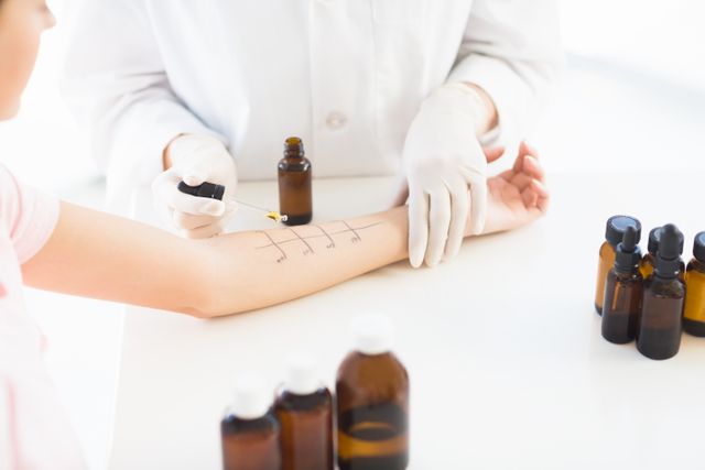 Doctor conducting an allergy test on a patient's arm using a dropper and marking the skin. Ideal for use in medical, healthcare, and educational materials to illustrate allergy testing, patient care, and medical procedures.