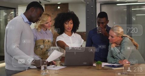Professional team collaborating around laptop with woman leading presentation and strategy