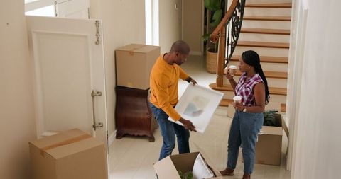 Couple Unpacking in New Home with Boxes and Artwork