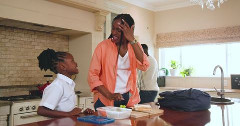 Mother Packing Lunch for Daughter in Stylish Home Kitchen