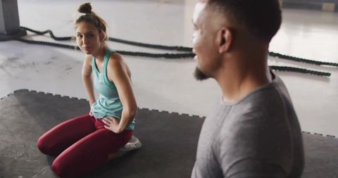 Woman Practicing Balance in Gym with Battle Ropes in Background