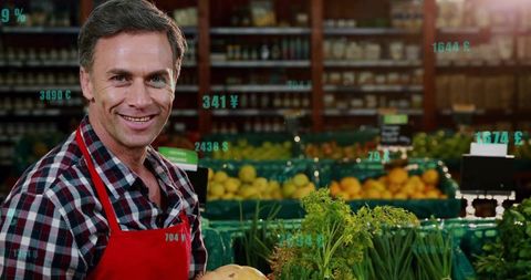 Smiling vendor with fresh produce displaying digital prices