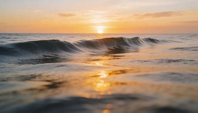 Golden sunrise over calm ocean wave low-angle water-level seascape with soft reflections