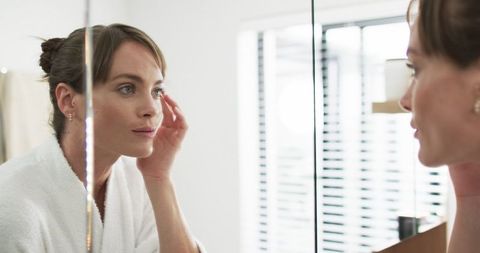 Woman Checks Skin in Bathroom Mirror Routine Morning
