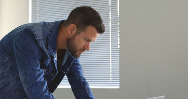 Man in Denim Jacket Working on Laptop in Office - Download Free Stock Images Pikwizard.com