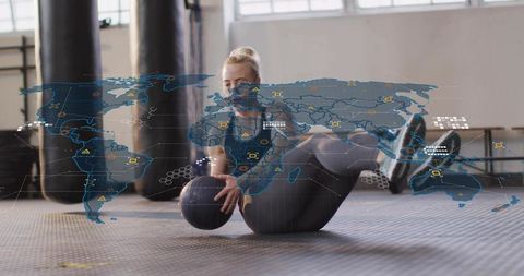 Female athlete performing russian twist with medicine ball and world map data overlay