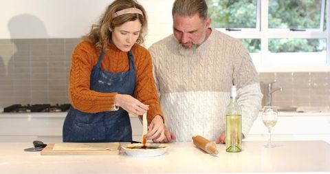 Couple Baking Homemade Pie Together in Cozy Modern Kitchen with Wine