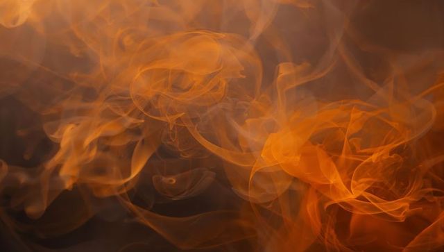 Abstract Fluid Swirling Smoke with Translucent Orange Patterns