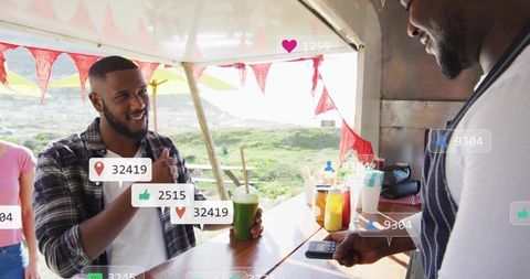 Smiling customer giving thumbs-up while buying green smoothie at seaside stall