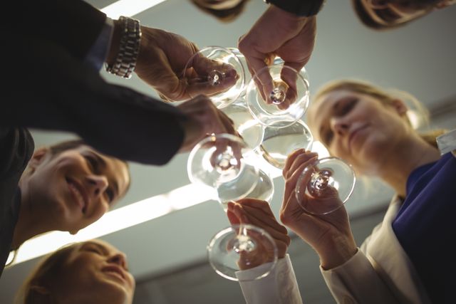 Business professionals celebrating success by toasting with champagne in an office environment. Ideal for illustrating corporate events, team achievements, networking gatherings, and professional celebrations.