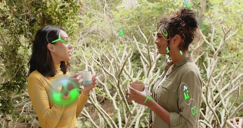 Women Chatting on Garden Patio Holding Coffee Mugs with Eco Graphics and Greenery