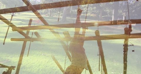 Man climbing on outdoor obstacle course in park