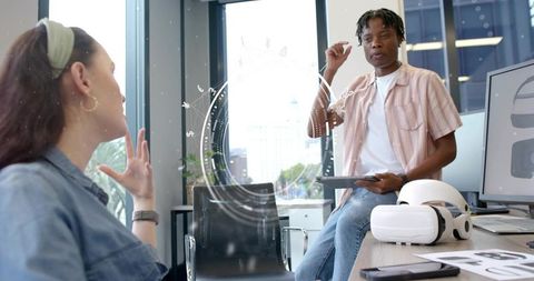 Black man presenting vr concept to colleague in office during tech brainstorming meeting
