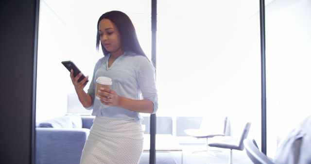 Confident Businesswoman Walking in Office with Coffee and Smartphone - Download Free Stock Images Pikwizard.com