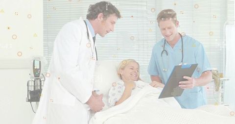 Physician and nurse reviewing chart while comforting smiling patient in hospital bed