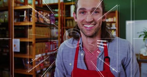 Cheerful Store Employee in Red Apron Arranging Stock on Shelves
