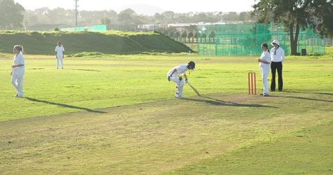 Female cricket players observing on green field during match