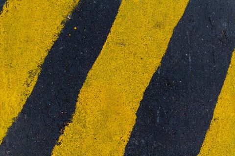 Asphalt road with bold yellow stripes