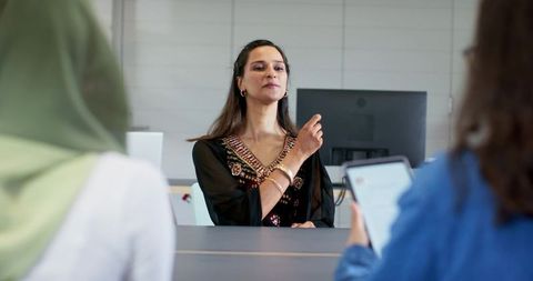 Confident businesswoman in black kurta leading boardroom panel discussion and negotiation