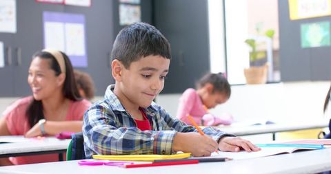 Boy writing focused on classroom activity