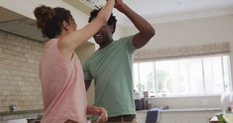 Couple Joyfully Dancing in Sunny Kitchen