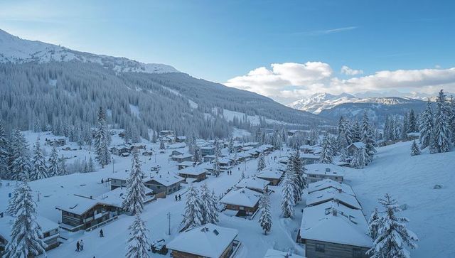 Snowy alpine village nesting in sunlit mountain valley with wooden chalets and pines
