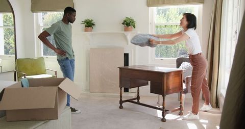 Couple unpacking in bright living room during move