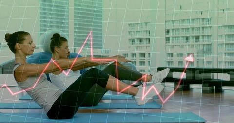 Two Women Performing V-Sit Core Workout in Urban Studio with Fitness Data Overlay
