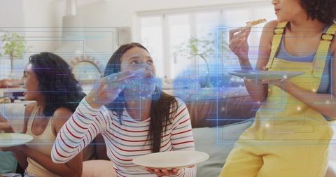 Friends sharing pizza on couch interacting with futuristic holographic interface