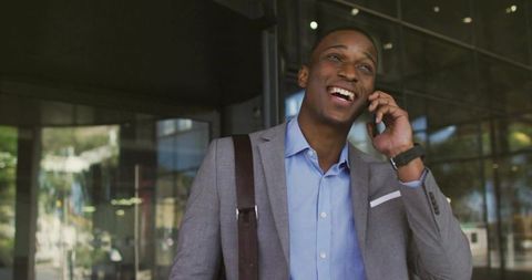 Confident Businessman Smiling While Communicating via Smartphone
