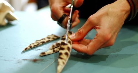 Craftsperson cutting patterned leather in artisan workshop