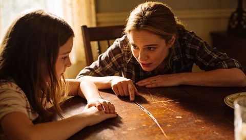 Mother pointing at table scratch teaching daughter about family memory and repair