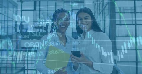 Two Professional Women Collaborating in Modern Office Corridor with Financial Charts Overlay