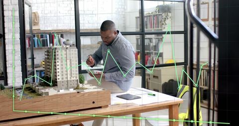 African american architect analyzing building model with data overlay
