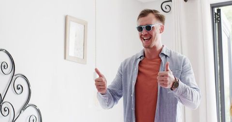 Excited Man Wearing Glasses Gives Thumbs Up at Home