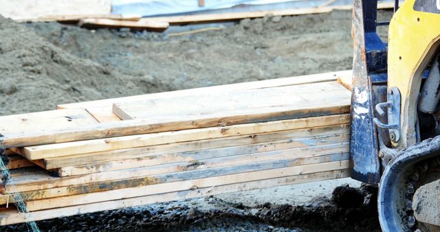 Construction Site with Stacked Wooden Planks and Lifting Machinery - Download Free Stock Images Pikwizard.com