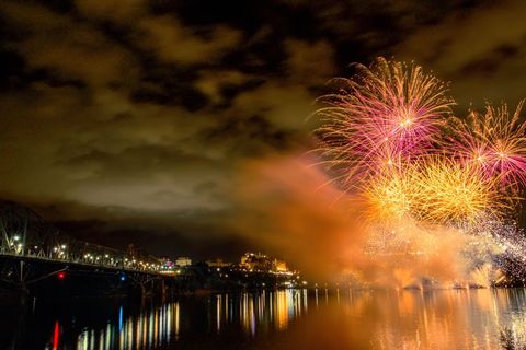 Cover background vibrant fireworks illuminate night sky over reflective river